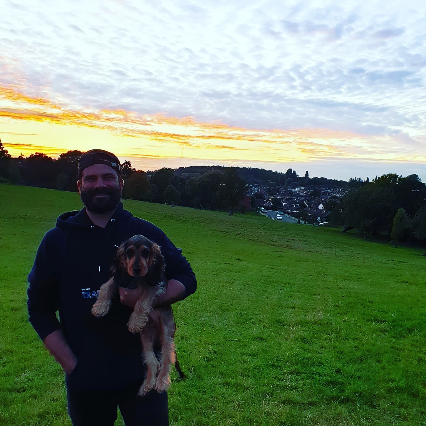 Matt holding a cocker spaniel puppy at sunset